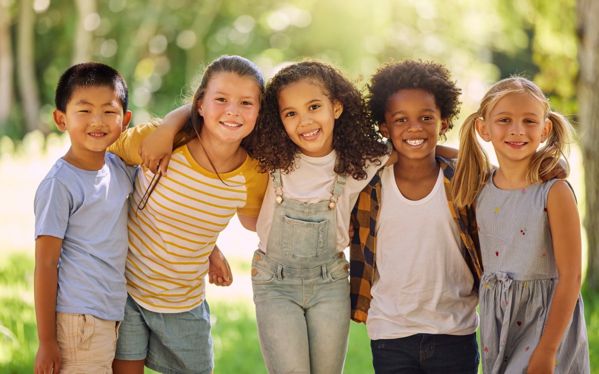 Group of five smiling children outdoors, promoting a positive dental experience at Fairhope Children's Dentistry.